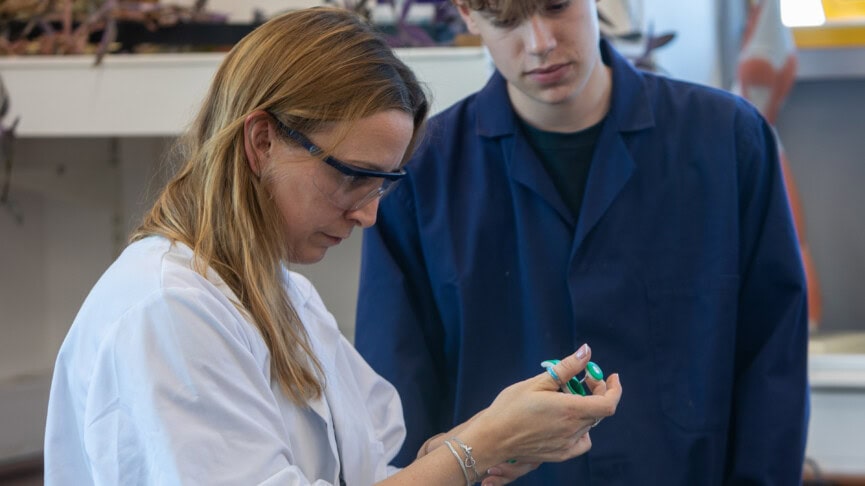 A teacher helping a student in a biology lab