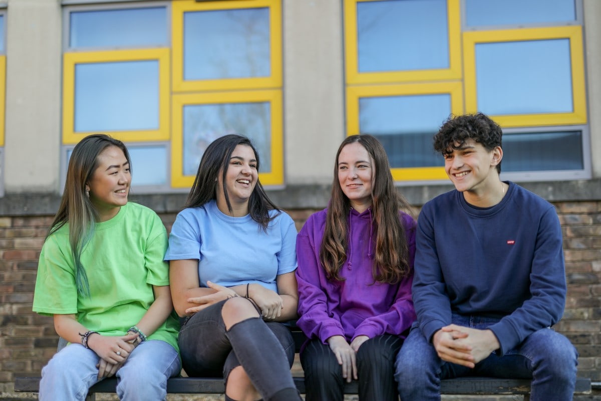 Photo of 4 students on a bench