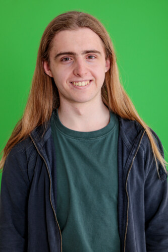 Boy Standing Against Green Background