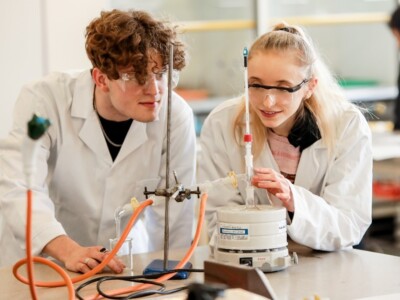 Two Science Students In Lab white coats doing an experiment