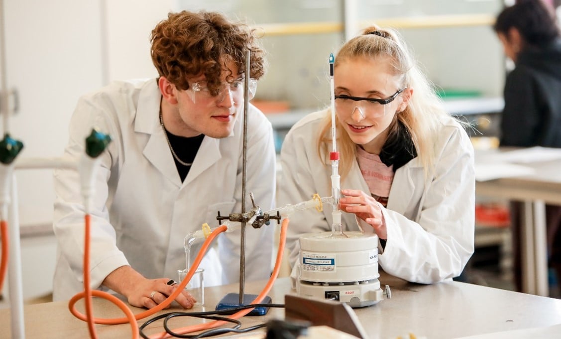 Two Science Students In Lab white coats doing an experiment