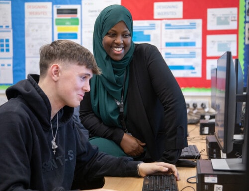 IT teacher with boy at computer