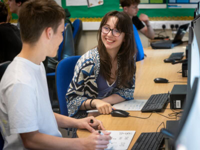 A male and fmale student working together in front of a computer