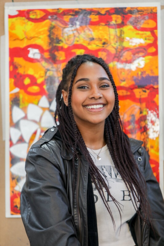 Fine Art student standing in front of her work