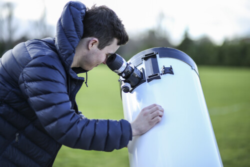 Physic Student Looks Through A Telescope