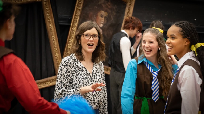 Teacher with drama students reading a script