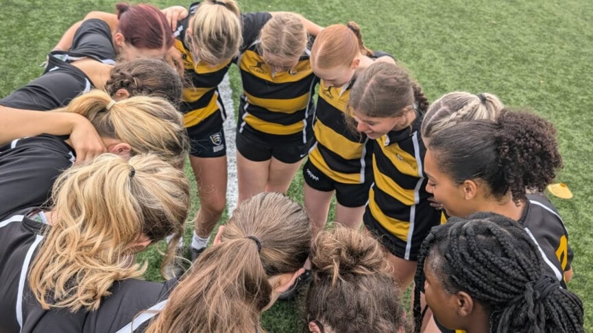 womens rugby team in a huddle