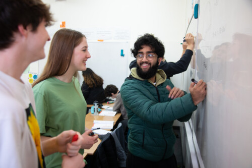 Mixed students working at whiteboard