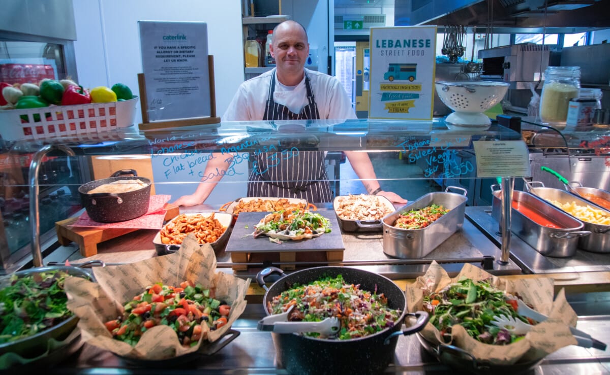 Photo of our Chef with the hot food on offer for the day