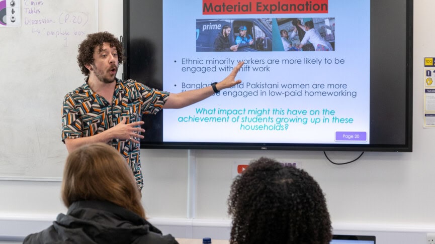 a sociology teacher explaining material on the whiteboard