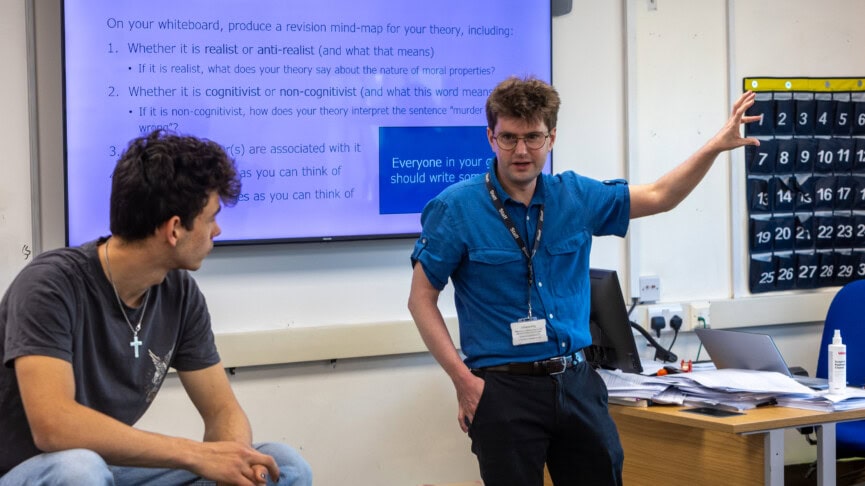 Philosophy teacher talking to students in a classroom