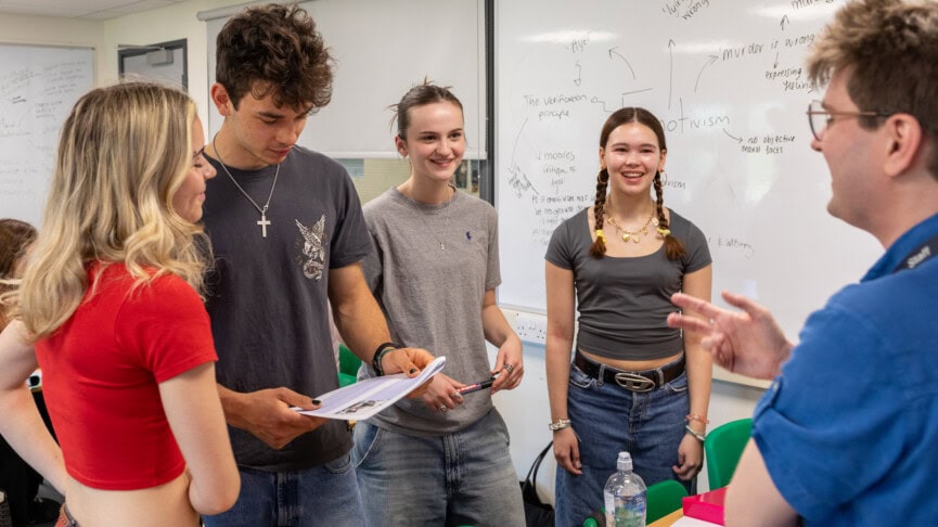 teacher and students debating in a group in a group in a philosophy classroom