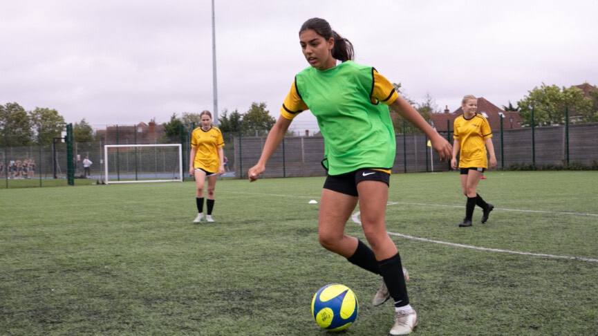 female football player kicking aball