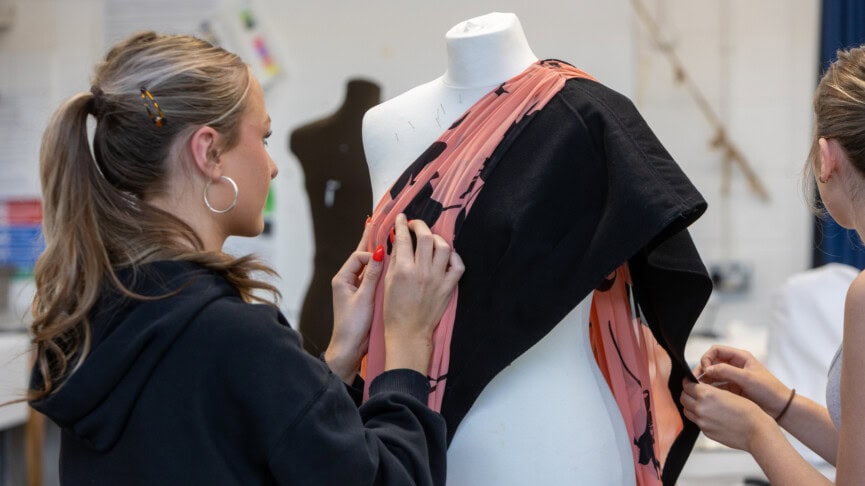 fashion student dressing a mannequin