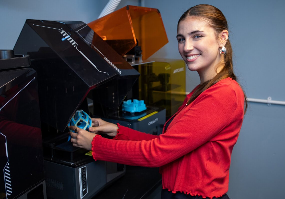 A female 3d design student using a 3d printer