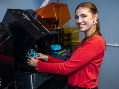 A female 3d design student using a 3d printer