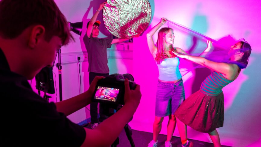 Students on set filming other students with pink lighting
