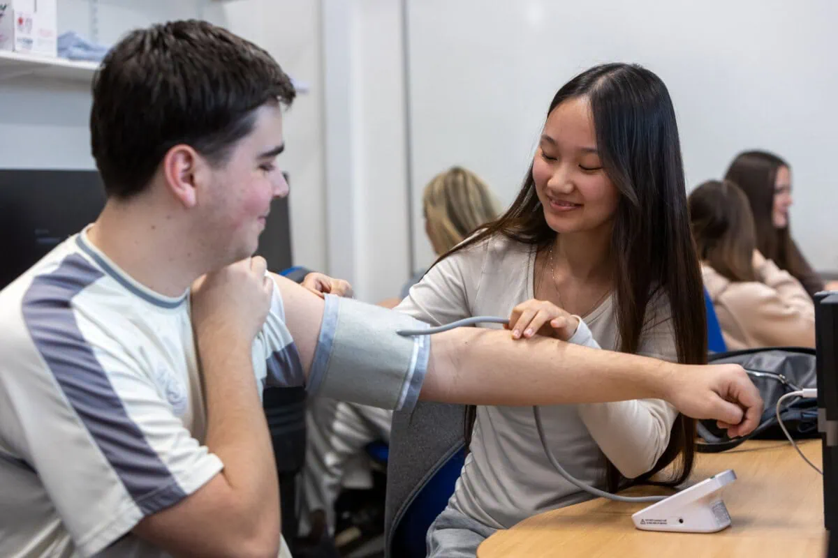 health and social care students performing a blood pressure check