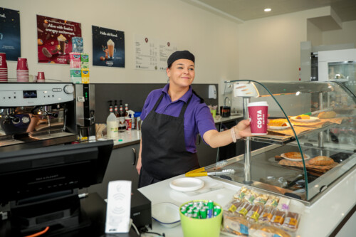 Lady handing over Costa coffee at Coffee bar