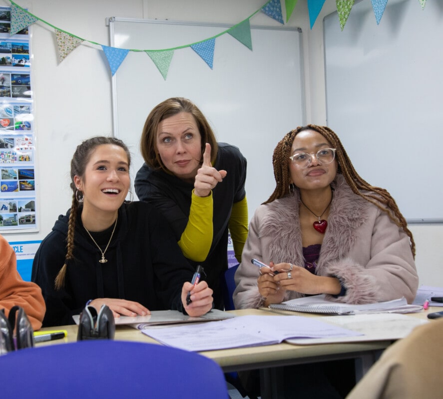 Business teacher with students pointing