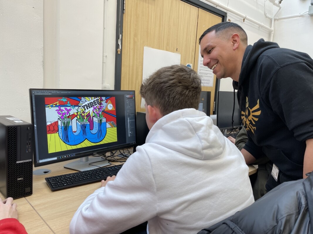 Graphic Communications Teacher helping student at the computer