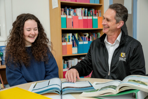 Teacher And Student Looking At Book At Laughing