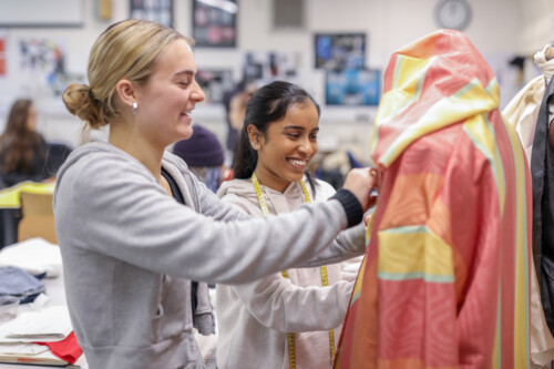 Two Girls Sewing A Garment