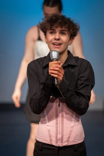 Male student performing on stage with microphone
