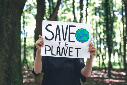 Person holding save the planet poster