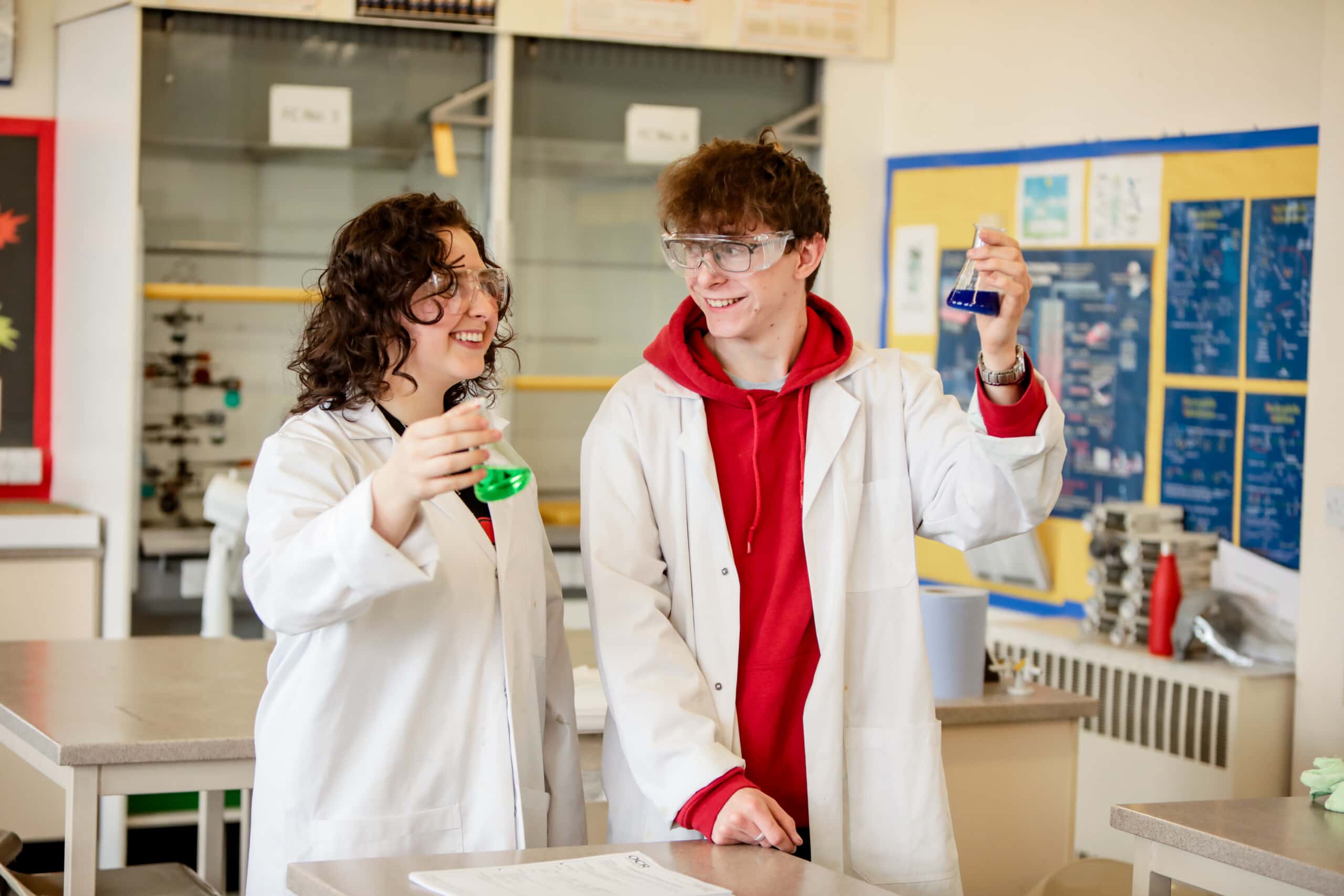 Male and female students in a practical chemistry lesson