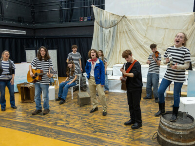 Esher band supports a singing student on stage in college production