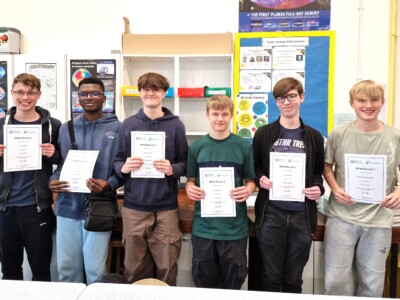 Group of male students holding up their Physics Olympiad Certificates