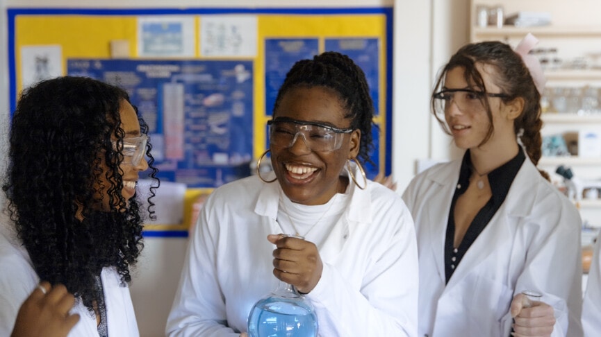 three chemistry students in white coats