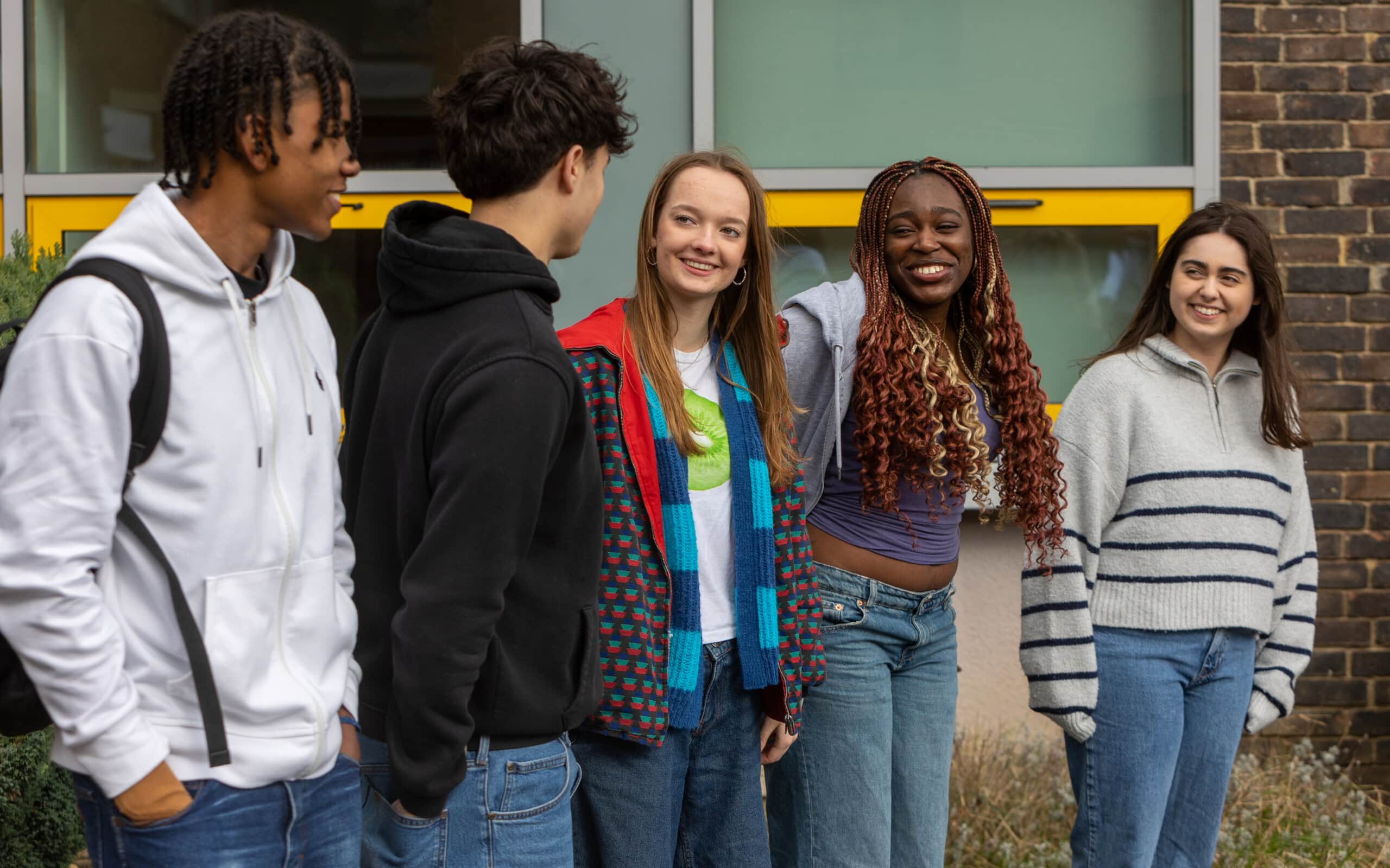5 students walking out of the college