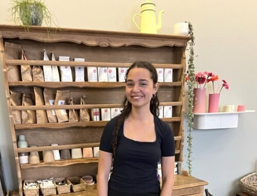 Student standing in front of a shop shelf In french Boulangerie