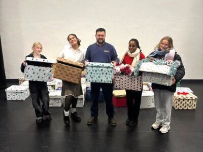 A group of five holding finished Christmas hampers