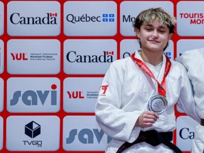 Judo competitor standing on the podium with a silver medal around her neck