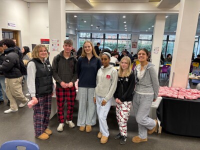 Student Union in pyjamas standing as a group in the cafe