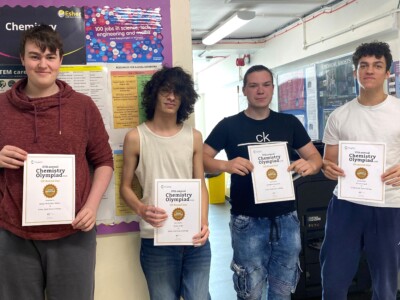 4 male students holding up certificates