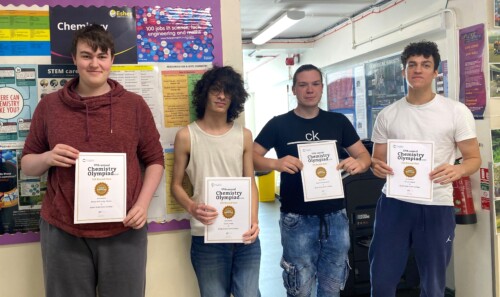 4 male students holding up certificates