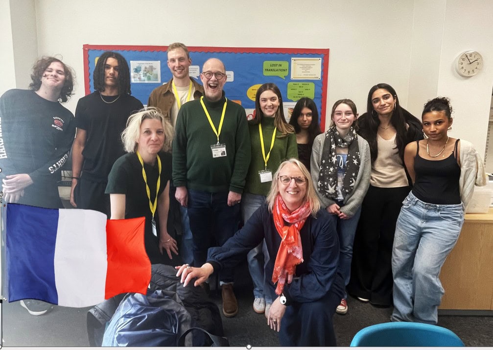 Languages students gathered in a group at the front of a classroom for a photo