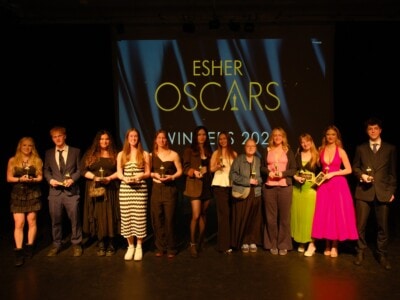 Students standing on a stage with Oscar statues