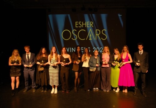 Students standing on a stage with Oscar statues