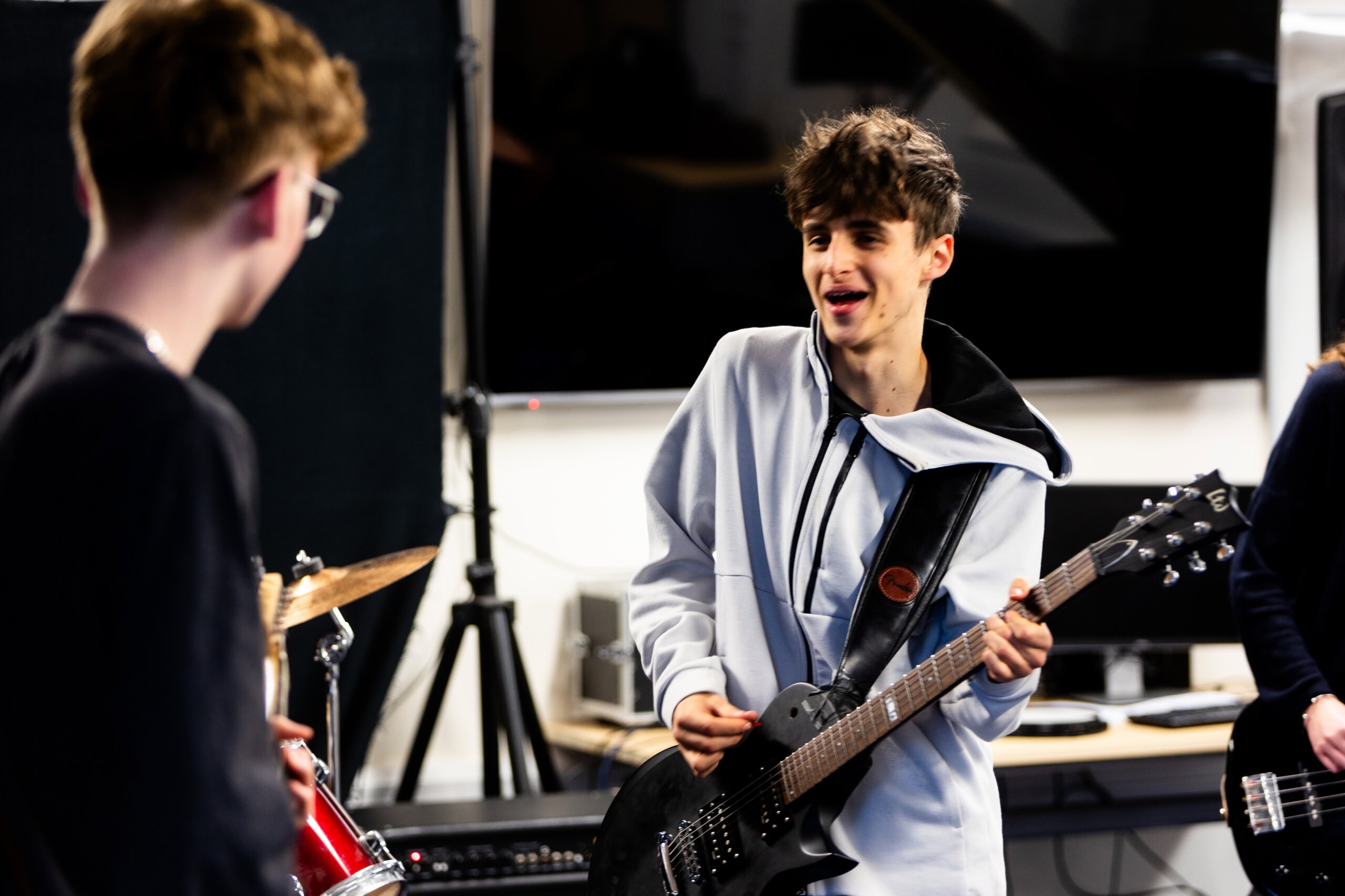 Male students in music room playing electric guitars