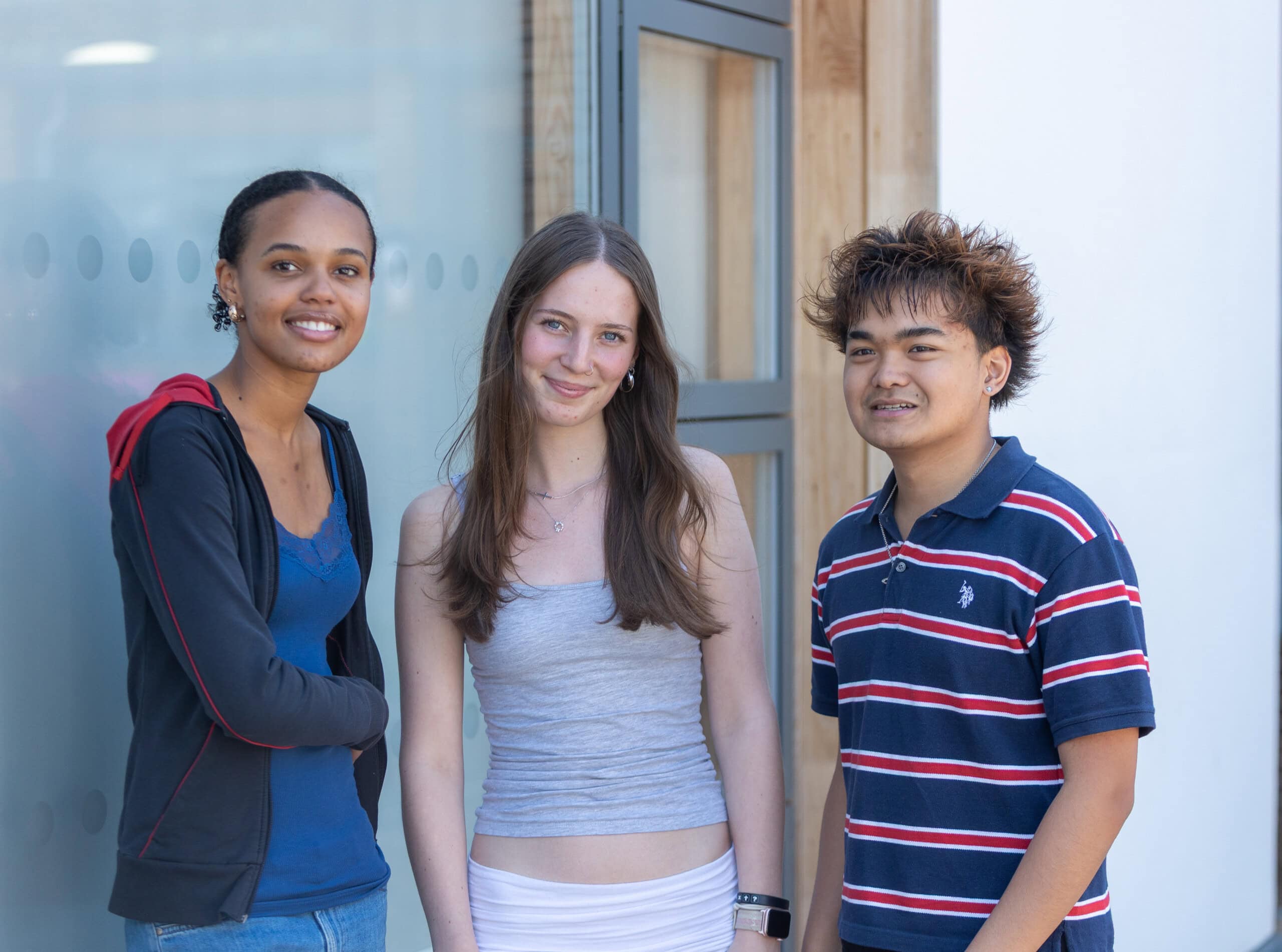 a group of three students at college looking relaxed