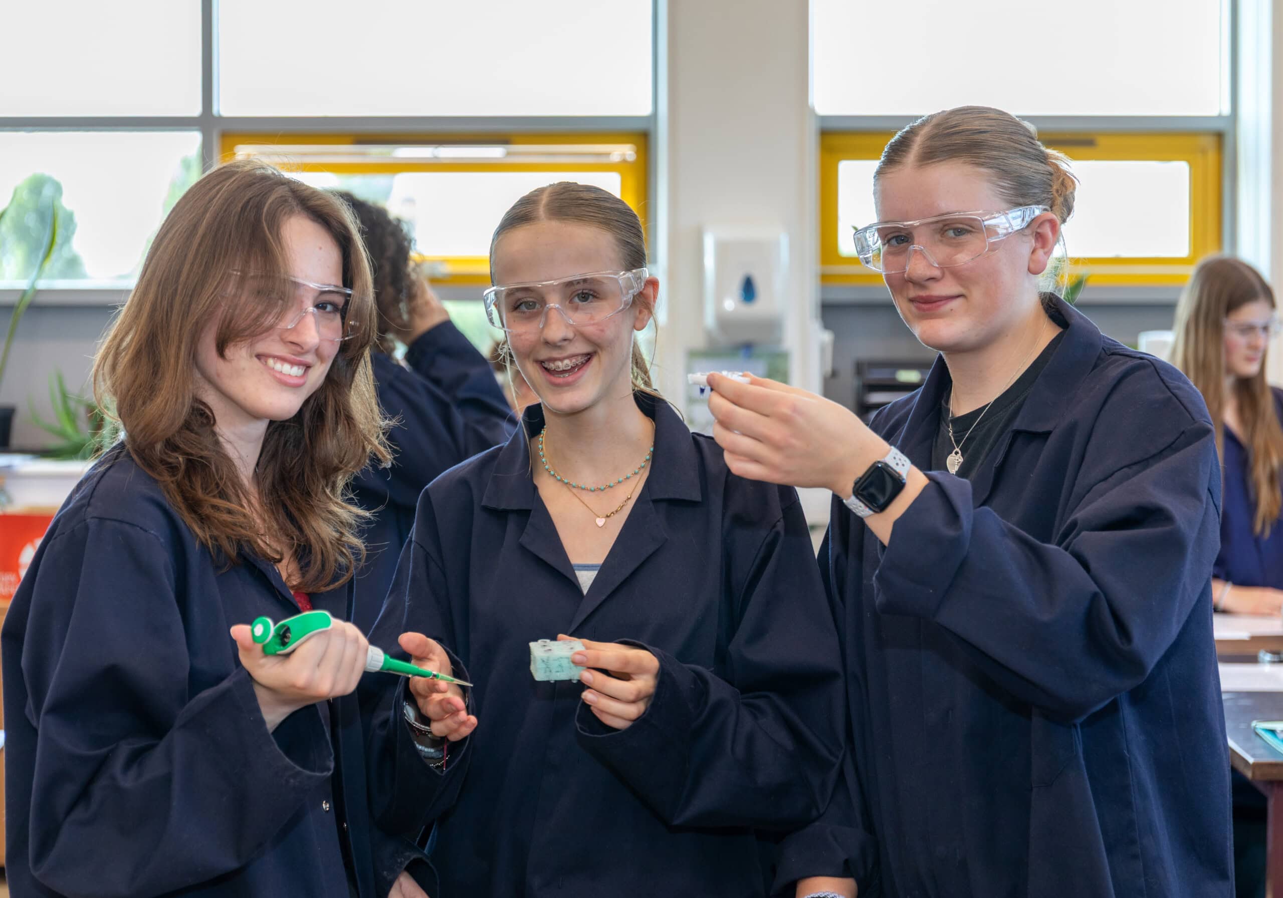 female student sin laboratory coats in a biology lesson