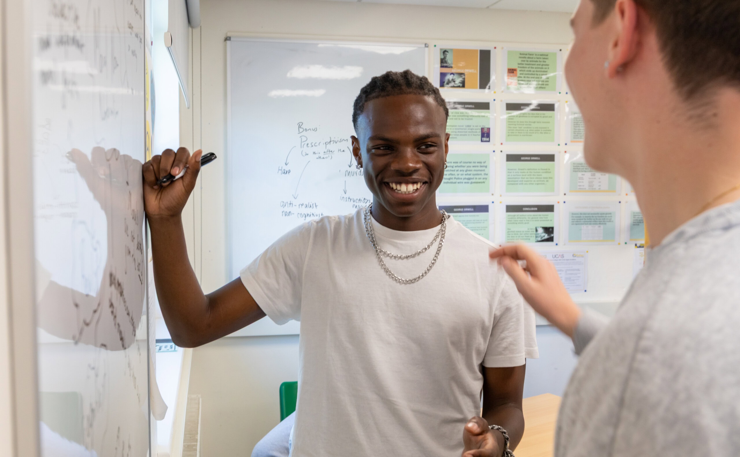 male student laughing at whiteboard