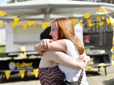 two female students hug at Esher College Results Day 2025