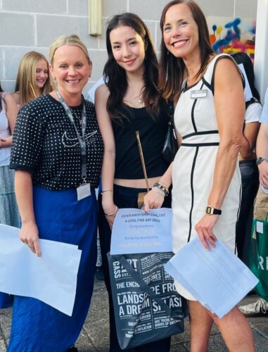 Art student stand inbetween her two teachers smiling Art Result