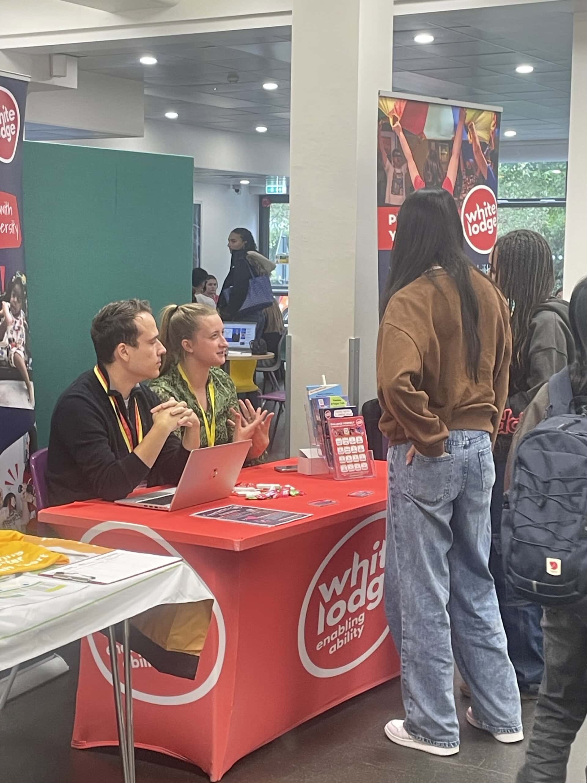 One of the stands at an employer fair with student asking about job opportunities.